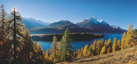 Le lac de Sils en automne se trouve au milieu d'un paysage de montagne recouvert de neige.