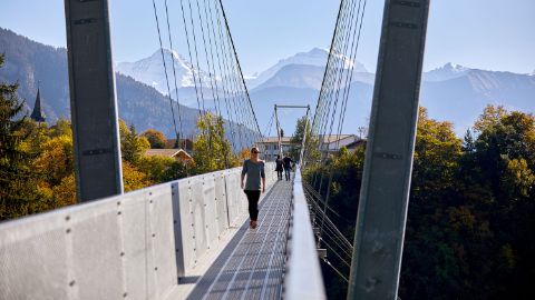 Personen, die die Betonbrücke auf dem Panoramaweg am Thunersee überqueren