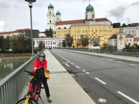 Prisca mit dem Velo auf der Brücke vor der St.Stefans-Kathedrale in Passau.