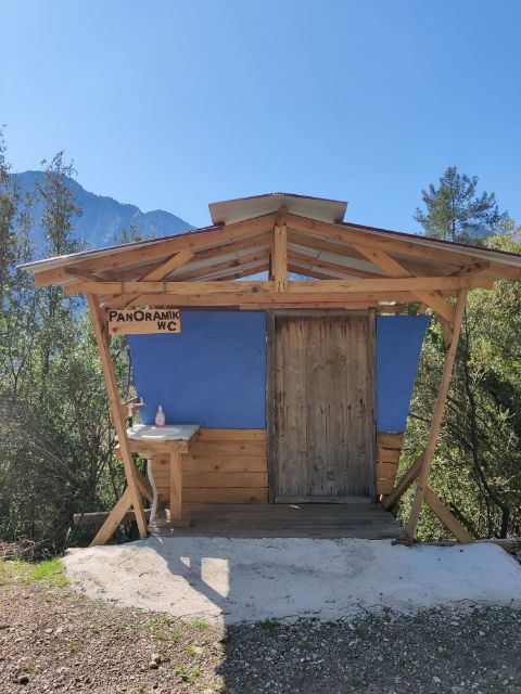 Eine Holzhütte beschriften mit Panoramic WC befindet sich im Wald 