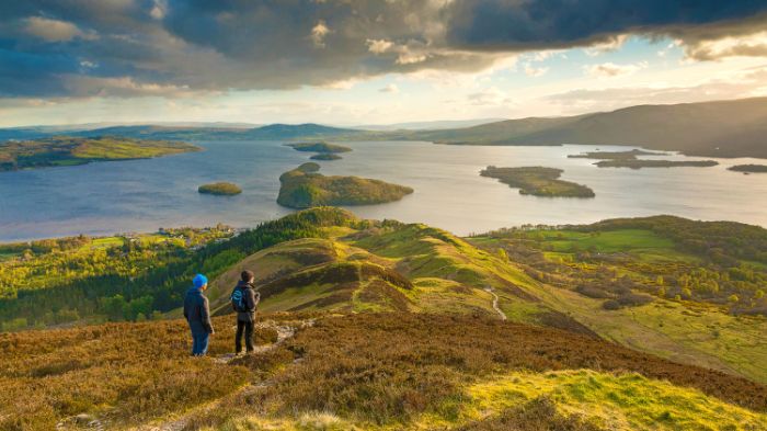 Two hikers looking at Loch Lomond in Scotland