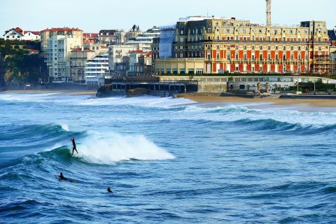 Surfer in den tobenden Wellen der Küste vor der Stadt Biarritz