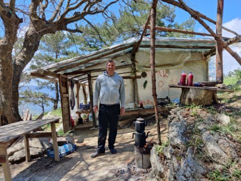 Türkischer Mann steht vor Zelt und macht Granatapfelsaft davor 