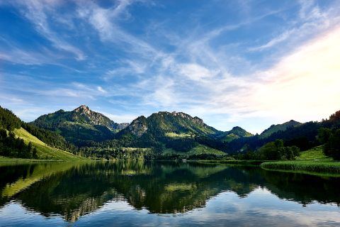 Lake Schwarzsee surrounded by green mountains in the background